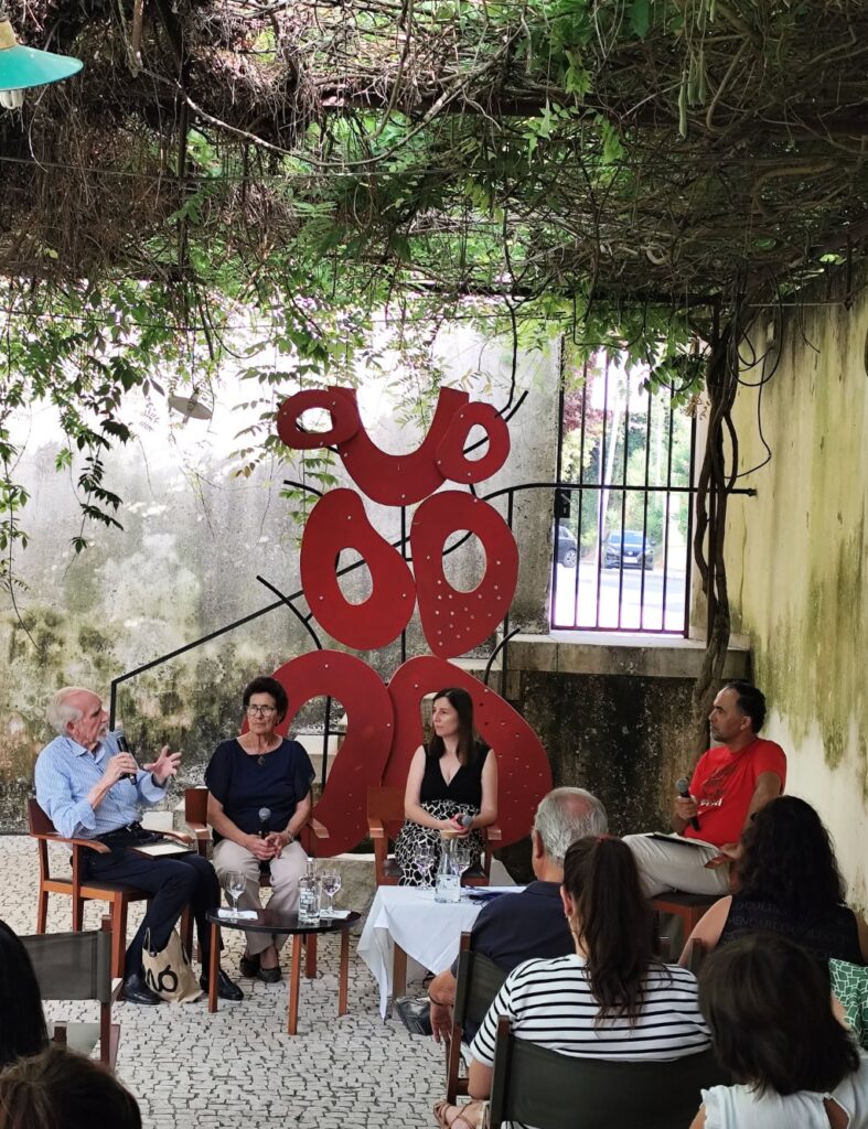 A public conversation beside the Baci Sospesi installation in Leiria, with speakers and an audience.
